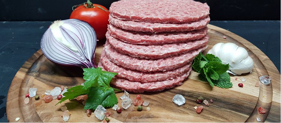 Stack of hand-pressed smashed burgers with onion, tomato and garlic