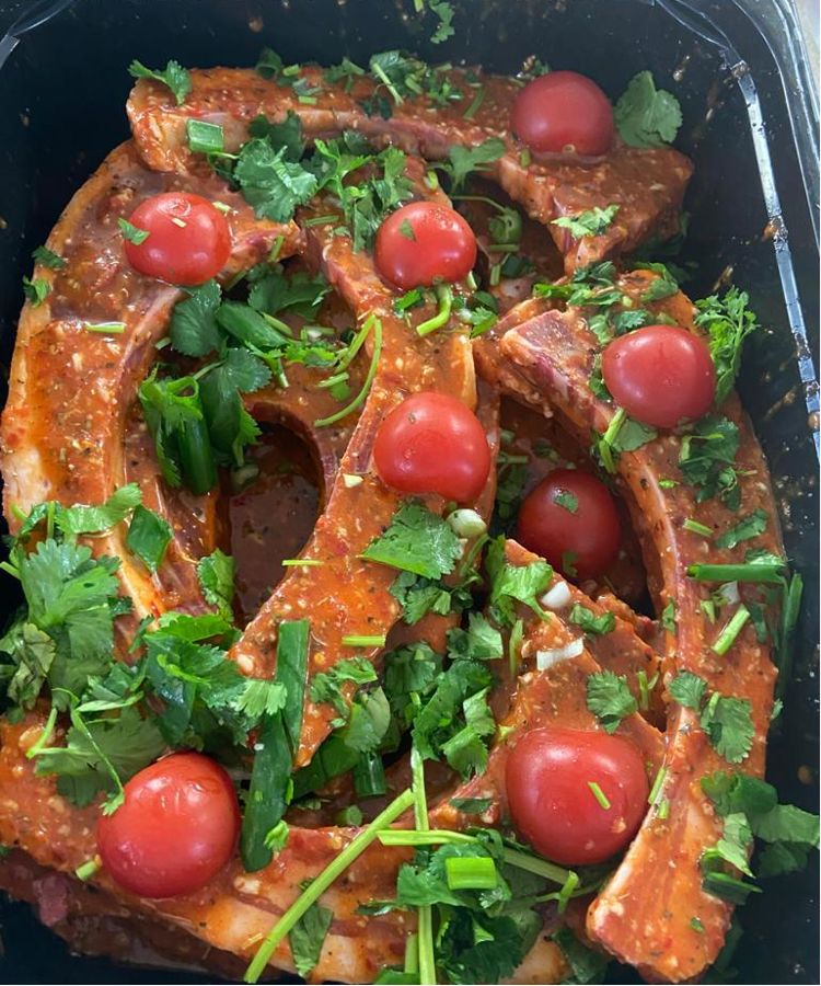 Marinated baby lamb ribs with tomatoes and coriander